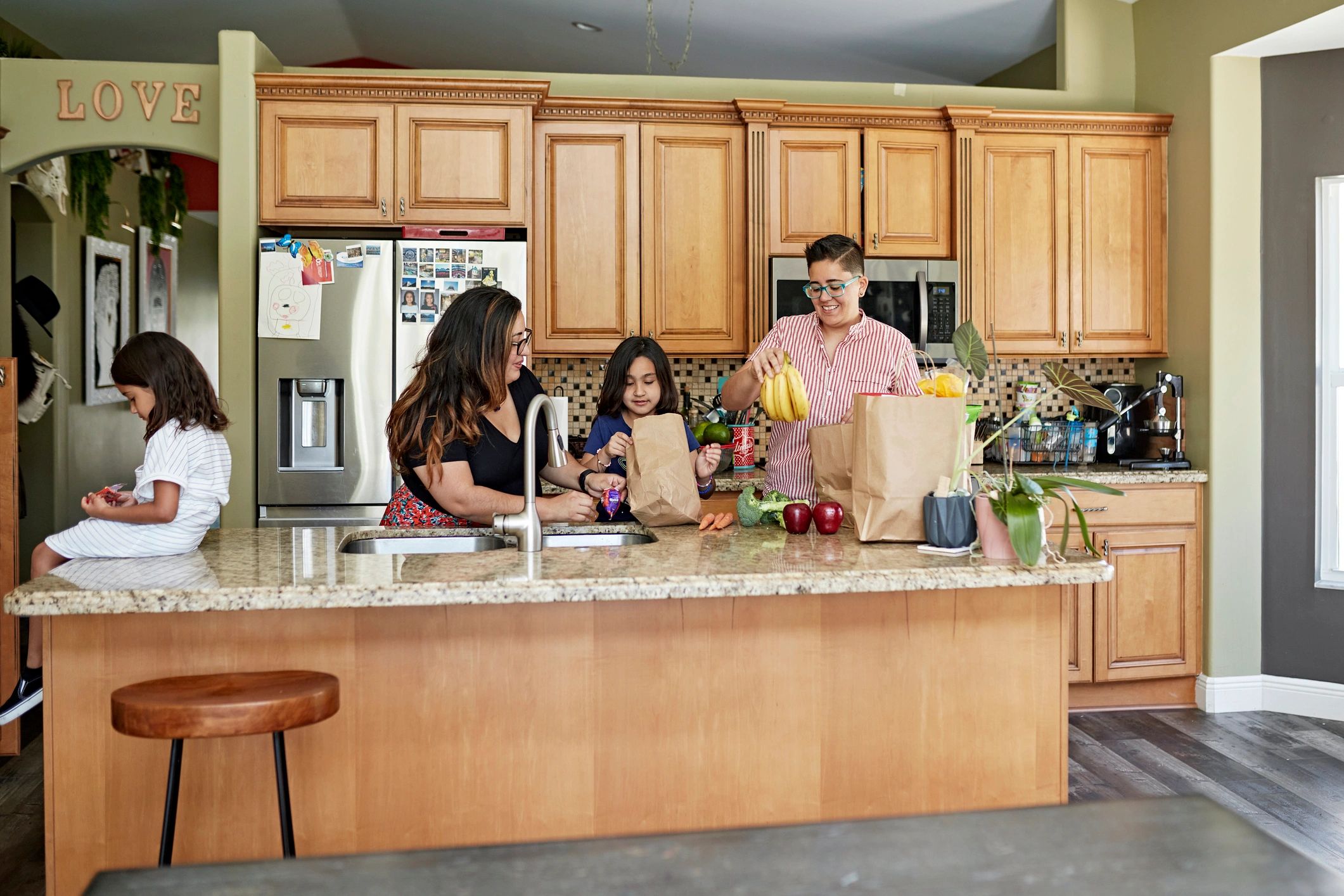 Family putting away groceries in a kitchen