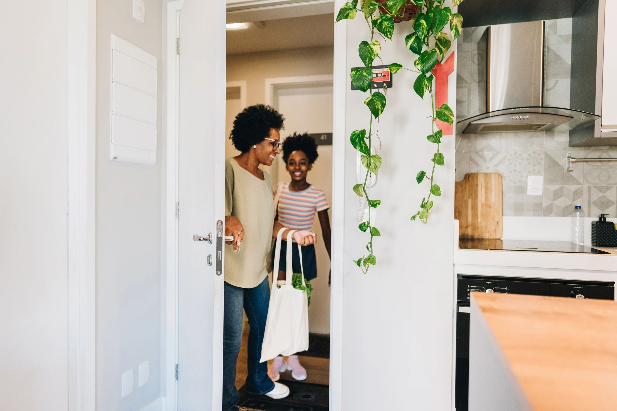 Parent and child bringing home groceries with reusable bags